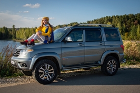 坐在越野车车盖上的旅行美女图片